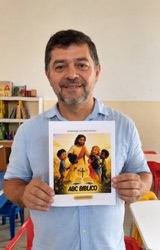 Professor de EBD segurando o material ABC Bíblico em sala de aula